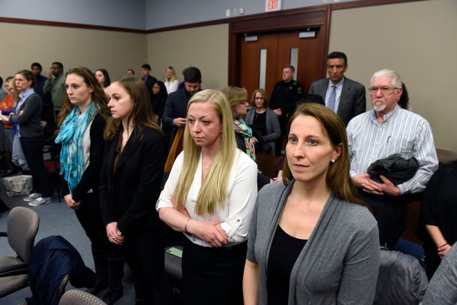 (From left) Former athletes and Larry Nassar abuse survivors Louise Harder, Grace French, Danielle Moore and Emily Meinke stand in the crowded  Ingham County Circuit Court February 11, 2020, for the trial of former MSU Gymnastics coach Kathie Klages. Klages is charged with lying to investigators and denies being told by young gymnasts about sexual abuse by Larry Nassar.