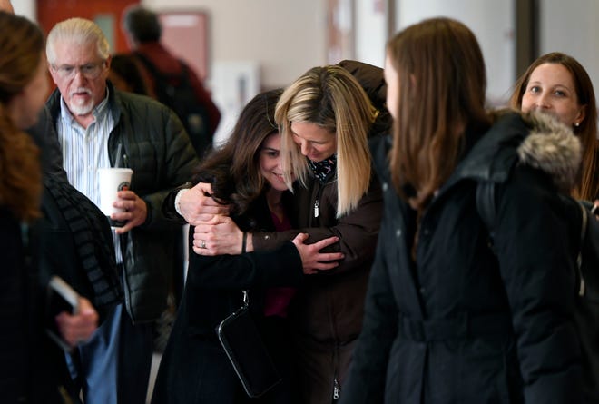 Former youth gymnast Larissa Boyce, center left, is hugged by fellow Larry Nassar abuse survivor Jen Hayes, center right, after Boyce testified in Ingham County Circuit Court in the trial of MSU Gymnastics coach Kathie Klages February 11, 2020. Klages is charged with lying to investigators and denies being told by young gymnasts about sexual abuse by Larry Nassar.