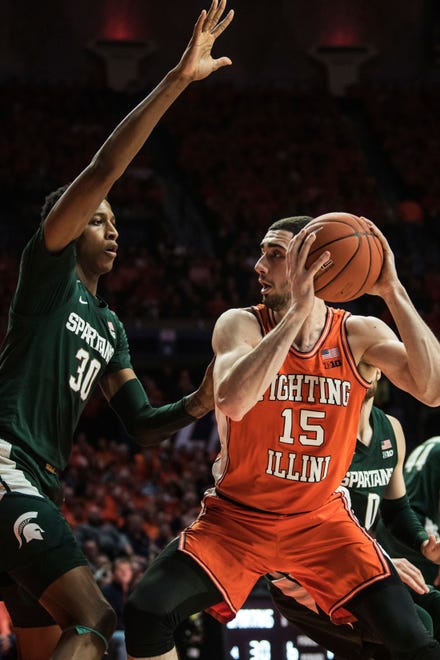 Illinois' Giorgi Bezhanishvili (15) looks to the basket as he is defended by Michigan State's Marcus Bingham Jr. (30) in the first half.