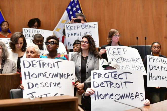 U.S. Rep. Rashida Tlaib, center, attends a rally in Detroit last year to announce a class-action lawsuit against the city for the overassessment of home values for thousands of homeowners.