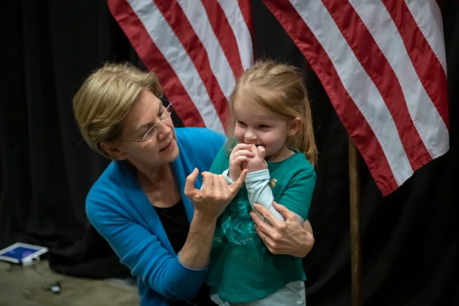Presidential candidate Senator Elizabeth Warren chats with three-year-old Adeline Chapman of Detroit, during a campaign stop inside Shed 5 at Eastern Market, in Detroit, March 3, 2020.