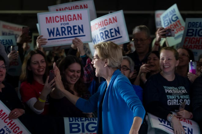 Presidential candidate Senator Elizabeth Warren high-fives the audience members before speaking during a campaign stop inside Shed 5 at Eastern Market, in Detroit, March 3, 2020.