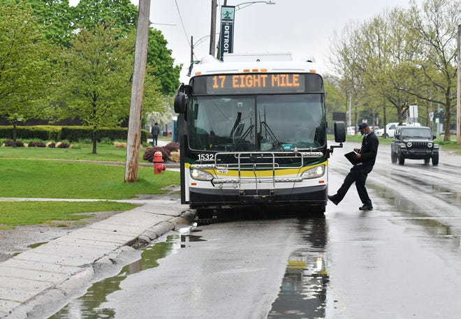 Driver Andrew Love checks out the exterior of his bus while stopped at the bus stop near Ascension St. John Hospital in Detroit on May 18, 2020. This is the halfway point of the eastbound loop from the State Fair Transit Center and sits here for approximately 30 minutes.  To protect the health and safety of our customers and employees, DDOT is temporarily suspending fare collection for all trips and requesting that customers limit non-essential bus travel until further notice.