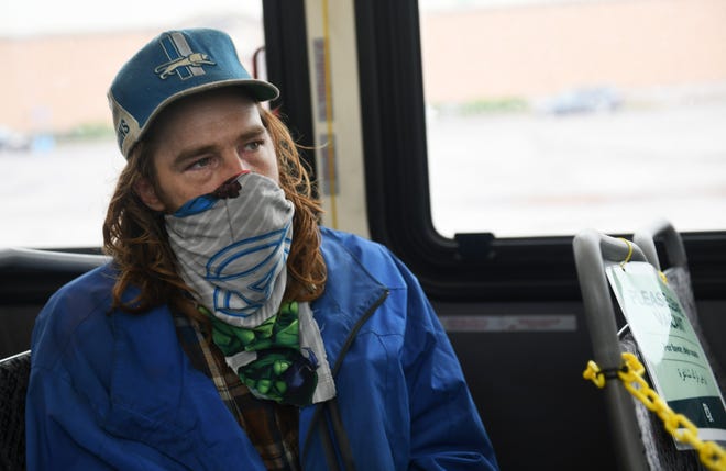 William McLoven, 35, of Detroit talks about riding the DDOT bus in Detroit on May 18, 2020. McLoven, who says he is homeless and squats in an empty home, made his mask from a bedsheet and says he makes one every few days. To protect the health and safety of our customers and employees, DDOT is temporarily suspending fare collection for all trips and requesting that customers limit non-essential bus travel until further notice.