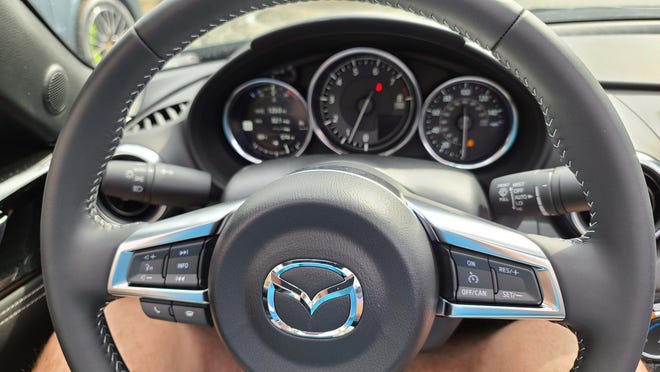 The steering wheel isn't just for driving. The 2020 Mazda MX-5 Miata features buttons for cruise control. volume control and voice commands for Apple Car Play app.
