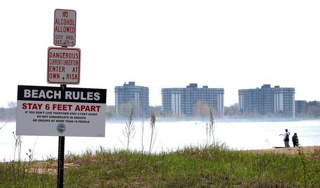 A beach-rules sign is displayed at Lighthouse Beach, Saturday morning, May 23, 2020, as Port Huron beaches are open, including, Lakeside Park beach. Visitors must follow social-distancing and group limit rules.