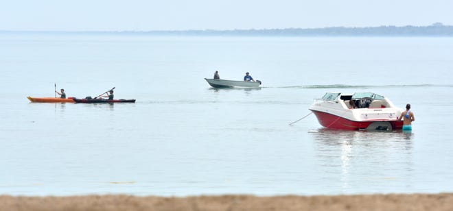 Kayakers and boaters play in the water off Lakeside Park beach.
