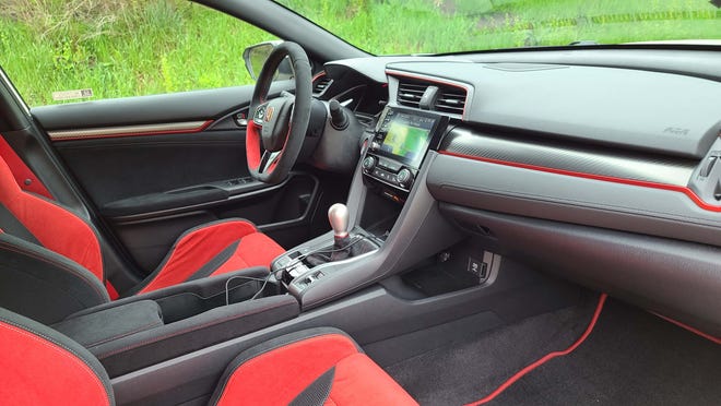 Honda's excellent ergonomics are visible even in the wild red interior of the 2020 Honda Civic Type R. The console is configurable, and there is even hidden space for phone charging ahead of the shifter.