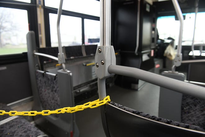 A plastic chain blocks the seating in the front portion of bus 17 to keep space between the driver and riders in Detroit on May 18, 2020. Riders use the rear door to enter and exit the bus. To protect the health and safety of our customers and employees, DDOT is temporarily suspending fare collection for all trips and requesting that customers limit non-essential bus travel until further notice.