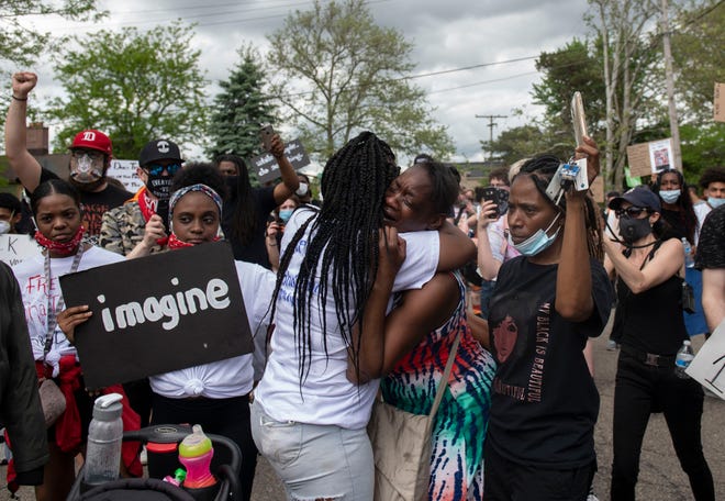 A family member of Sh'Teina Grady El begins to weep and is comforted during a protest Thursday, May 28, 2020, in Ann Arbor, Mich. A Michigan sheriff's deputy is seen on video punching Grady El in the head several times during her arrest early Tuesday, and another deputy tased her husband after the couple allegedly refused an order to leave the scene of a shooting.