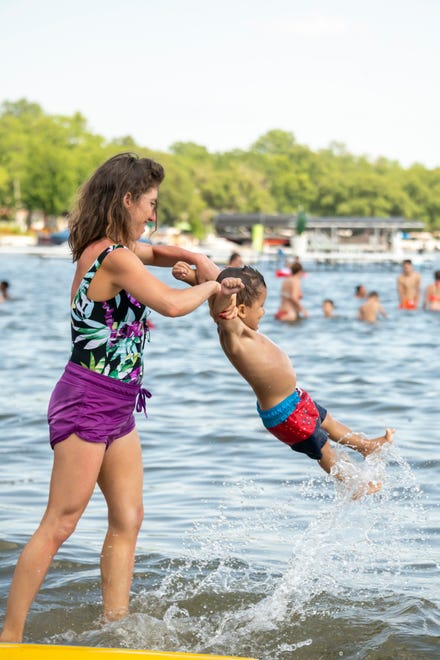 Malaki Naseraldeen, of Dearborn, plays with her 19-month-old son Ali during a day of warm weather at Mercer Beach, in Walled Lake, June 30, 2020.