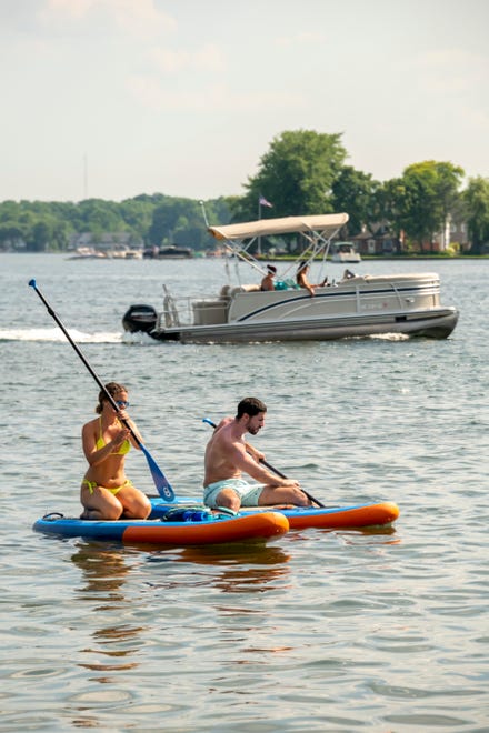 People enjoy paddle boarding and boating during a day of warm weather near Mercer Beach, in Walled Lake, June 30, 2020.