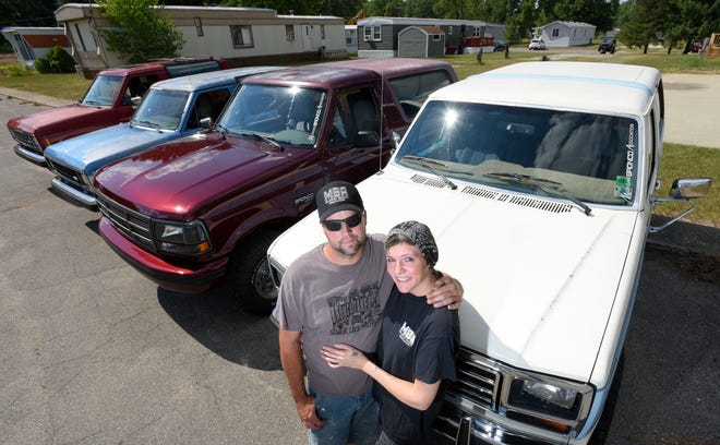 John Parks and his fiancee, Shanna Gibson, both of Highland Township, pose with their family's four Ford Broncos. The new Bronco will debut Monday.