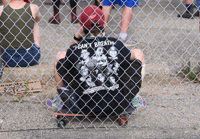 A protester displays his “I can’t breathe” shirt at the intersection of NcNichols Road and San Juan Road in Detroit on Saturday, July 11, 2020.