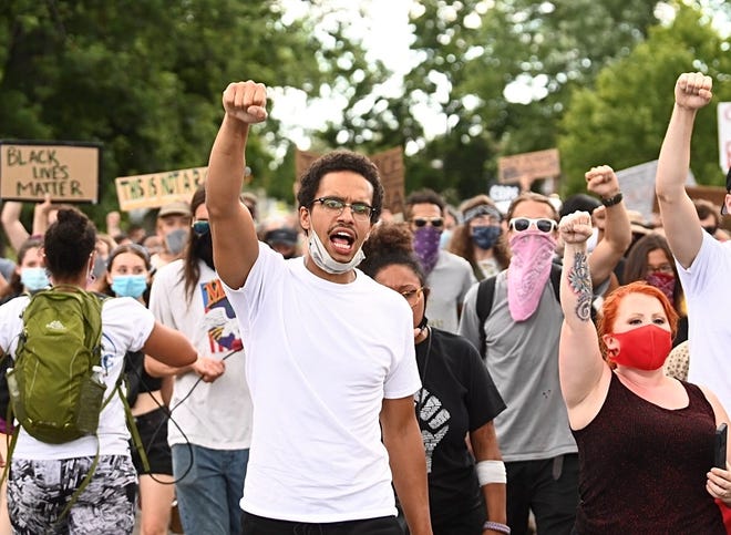 Protesters march and chant at the intersection of NcNichols Road and San Juan Drive in Detroit on Saturday, July 11, 2020.