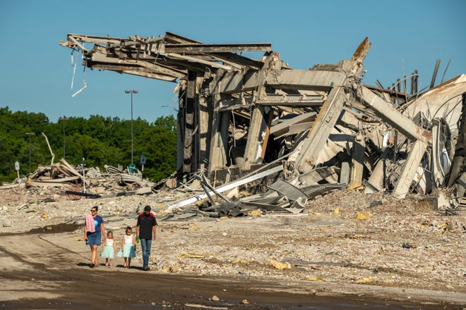 A family walks past the rubble that was once the Palace of Auburn Hills which was demolished in a controlled demolition, Saturday, July 11, 2020.
