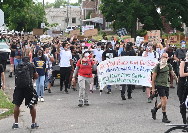 Protesters march and chant along San Juan Drive  as they head towards & Mile Road in Detroit.