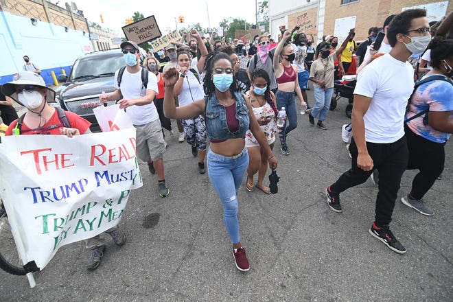 Protesters march and chant at the intersection of McNichols Road and San Juan Drive as they head towards 7 Mile Road in Detroit on Saturday, July 11, 2020.