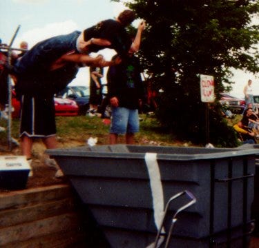 A fan tosses a fellow fan into a dumpster at the first Gathering of the Juggalos festival.