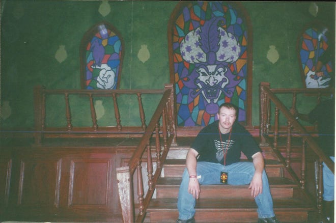 A fan poses on an old concert stage at the first Gathering of the Juggalos.