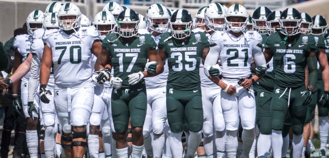 The Michigan State football program announced it has placed workouts on "pause" because one of its staff members tested positive for COVID-19, the athletic department announced Wednesday night.