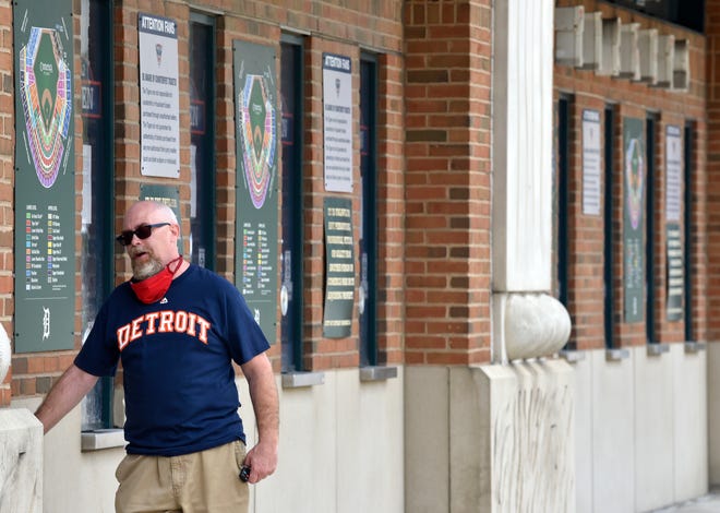 Tigers fan Todd Faber, of Melvindale, talks to Comerica Park employees at the ticket booths outside the stadium before visiting the gift shop. Very few fans were seen around Comerica Park, early Monday afternoon, hours before the Tigers' home opener on Monday, July 27, 2020. Due to the COVID-19 pandemic no fans were allowed inside to watch the game against the Kansas City Royals.