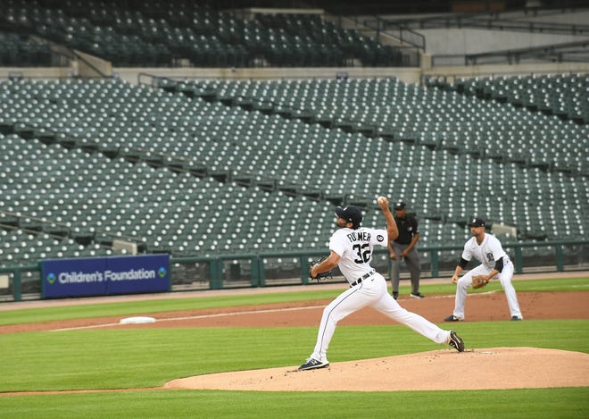 Tigers pitcher Michael Fulmer throws the first pitch in the first inning in front of no fans in a near-empty stadium on the strangest home opener ever in Detroit.