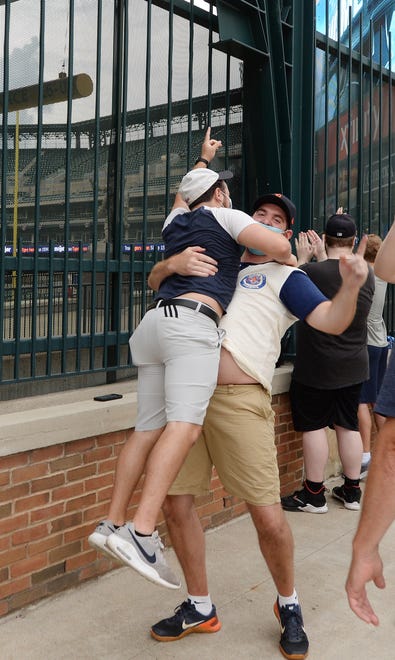 Tiger fans Corey Davis, 24, of Redford Township jumps into the arms of Eric Aaro, 29, also of Redford Township, after JaCoby Jones blasted a three-run homer in the second inning during the Tigers home opener at Comerica Park, Monday.