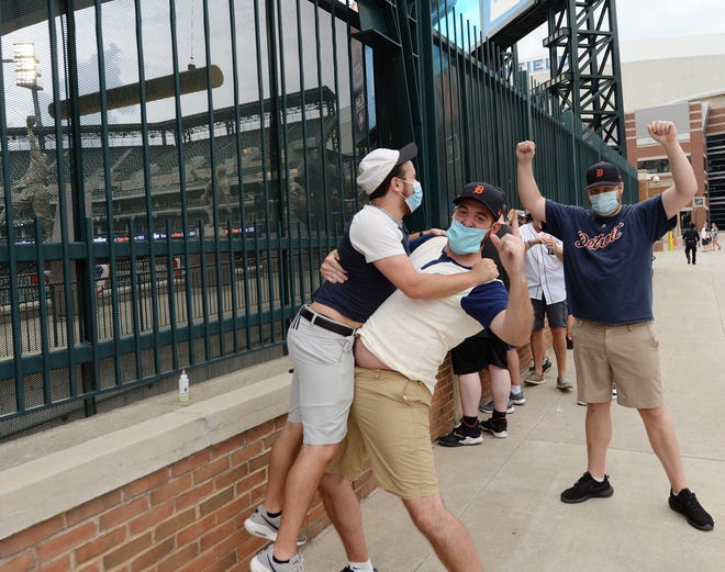 Tiger fans Corey Davis, 24, of Redford Township jumps into the arms of Eric Aaro, 29, also of Redford Township, after JaCoby Jones blasted a three-run homer in the second inning during the Tigers home opener at Comerica Park, Monday.
