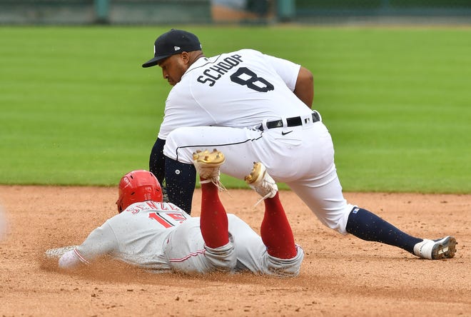 Reds ' Nick Senzel is safe sliding into second base on his double under Tigers second baseman Jonathan Schoop in the third inning.
