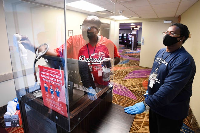 EVS specialists Darryl Lewis and Brien Smith clean the newly installed plexiglass on the final security check before guests enter the casino.
