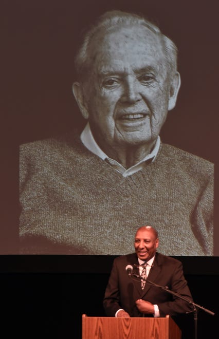 Chuck Stokes, a director at WXYZ TV Channel 7 in Detroit speaks at a memorial service Thursday for Michigan Governor William Milliken, seen on the video screen behind him, who died last October 2019 at the age of 97. Milliken was remembered today at the Interlochen Center for the Arts.