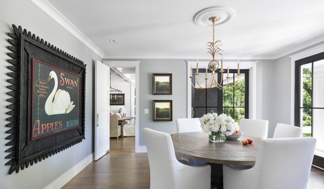 The dining room is a dedicated space with a door to the kitchen. Interior designer Richard Daniels said the swan art -- framed by a picket fence that he got from his sister -- was inspired by the many swans on Wing Lake.