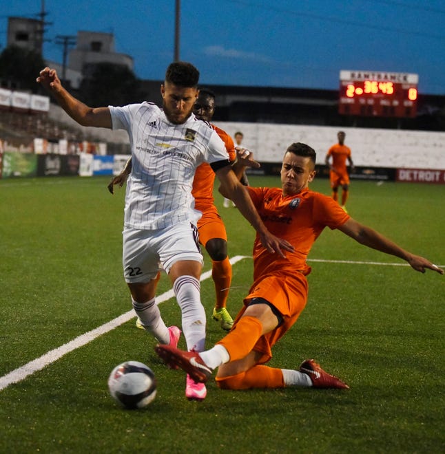 DCFC's Kevin Venegas and New Amsterdam FC's Alvarez chase down a ball in the first half.