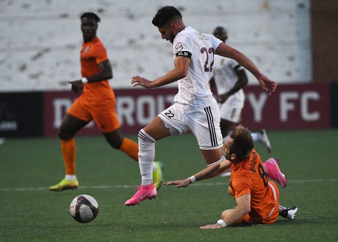 DCFC's Kevin Venegas leaps over New Amsterdam FC's Even Nadaner bringing the ball upfield in the first half.