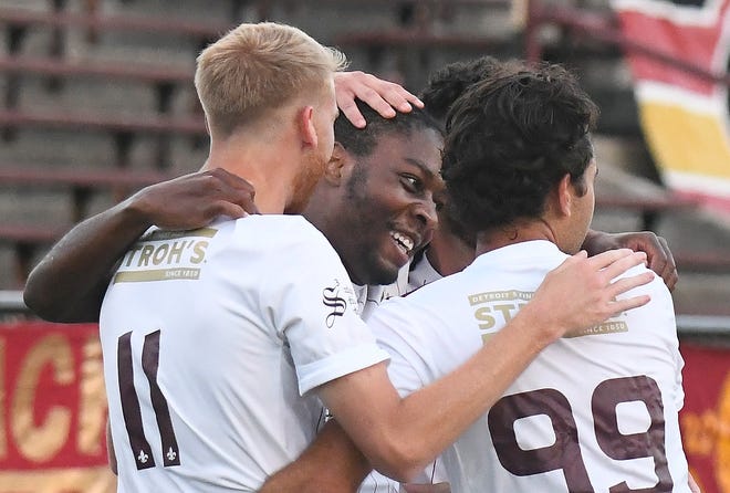 Teammates mob DCFC's Shawn Claud Lawson after his score in the first half of the 3-0 victory over New Amsterdam FC at Keyworth Stadium in Detroit, Michigan on September 5, 2020.
