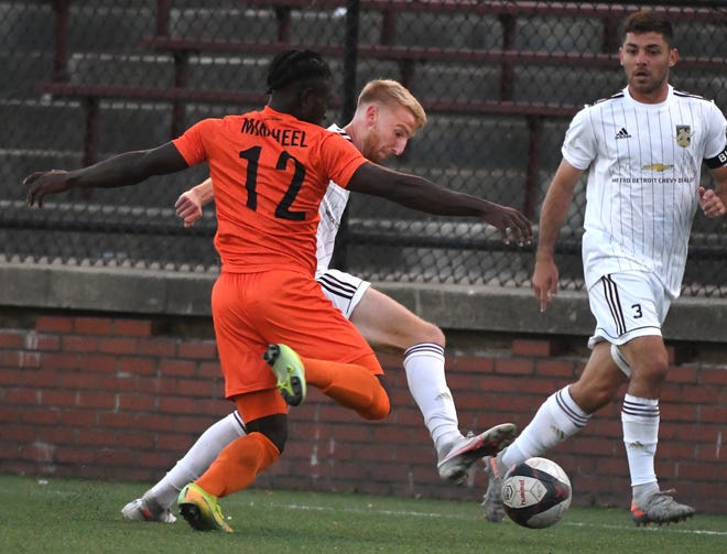 DCFC's Connor Rutz  brings the ball upfield against New Amsterdam FC's Yusuf Mikaheel in the first half.