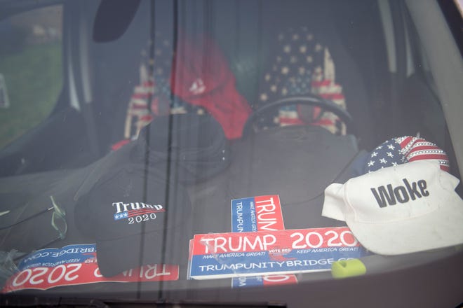 Trump stickers rest on the dashboard of a car.