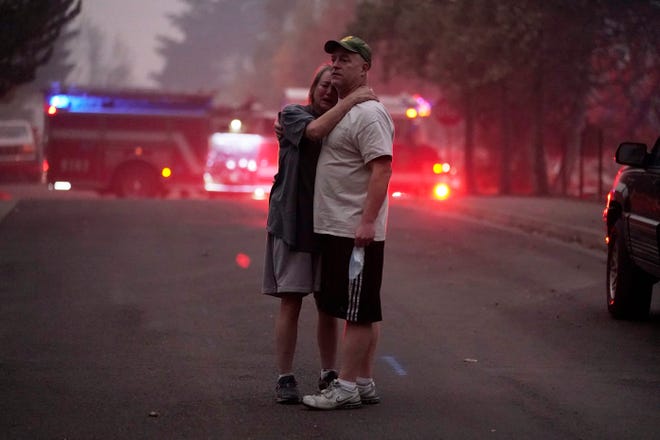 A couple, who declined to give their names, embrace while touring in an area devastated by the Almeda Fire, Thursday, Sept. 10, 2020, in Phoenix, Ore.
