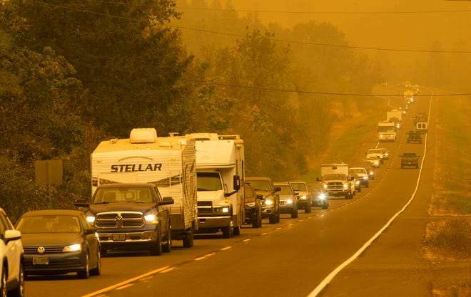 A steady stream of vehicles heads west on a road east of Springfield, Ore., as residents evacuate the area ahead of a fast-moving wildfire Tuesday Sept. 8, 2020.