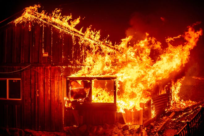 Flames shoot from a home as the Bear Fire burns through the Berry Creek area of Butte County, Calif., on Wednesday, Sept. 9, 2020. The blaze, part of the lightning-sparked North Complex, expanded at a critical rate of spread as winds buffeted the region.
