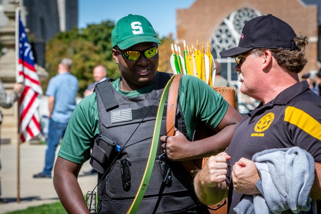 Jamiroquai Guy, left, 15, of Flint, Michigan holds a bow and  quiver of arrows as Barry County Sheriff Dar Leaf demonstrates how to hold them. Gun rights advocates rally for the Second Amendment March at the Capitol Building in Lansing, Michigan on September 17, 2020.