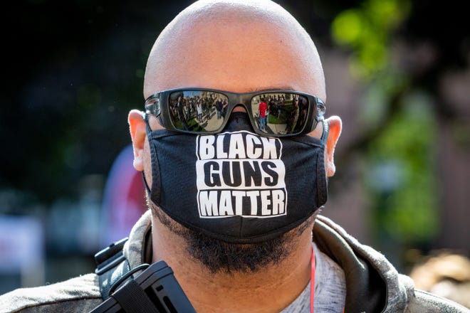 An armed man with a "Black Guns Matter" mask (name withheld) attends a rally for the Second Amendment March at the Capitol Building in Lansing, Michigan on September 17, 2020.