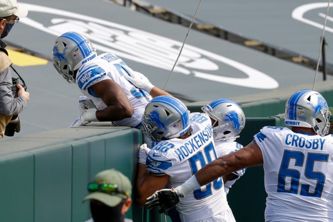 Detroit Lions' Kerryon Johnson does a Lambeau Leap after running for a touchdown during the first half of an NFL football game against the Green Bay Packers Sunday, Sept. 20, 2020, in Green Bay, Wis.