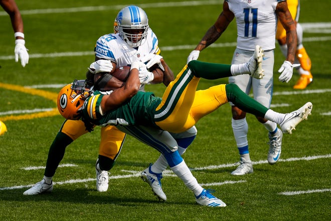 Green Bay Packers' Kevin King and Chandon Sullivan stop Detroit Lions' Adrian Peterson during the first half of an NFL football game Sunday, Sept. 20, 2020, in Green Bay, Wis.