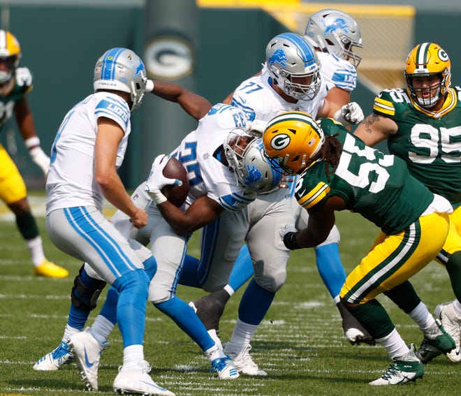 Green Bay Packers' Za'Darius Smith(55) is called for a facemask penalty against Detroit Lions' Kerryon Johnson(33)during an NFL football game, Sunday, Sept. 20, 2020, in Green Bay, Wis.