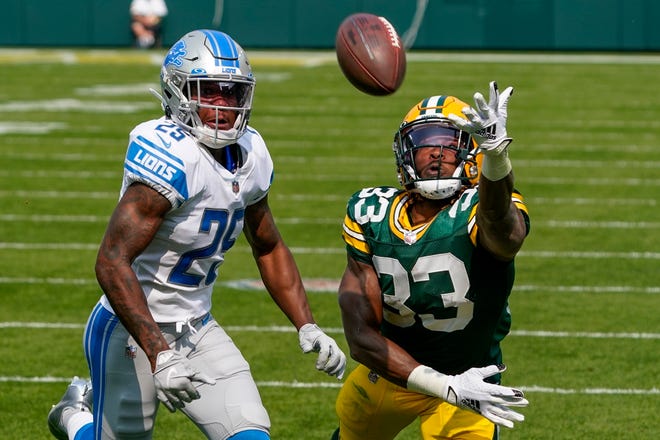 Green Bay Packers' Aaron Jones can't catch a pass in front of Detroit Lions' Will Harris during the first half of an NFL football game Sunday, Sept. 20, 2020, in Green Bay, Wis.