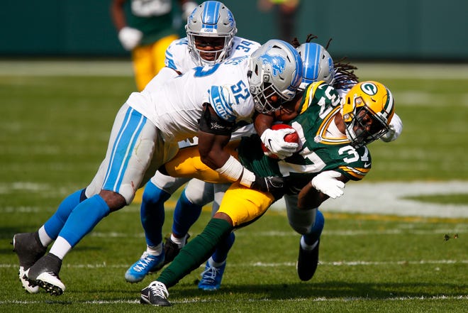 Green Bay Packers' Josh Jackson is stopped by Detroit Lions' Christian Jones (52) during the second half of an NFL football game Sunday, Sept. 20, 2020, in Green Bay, Wis.