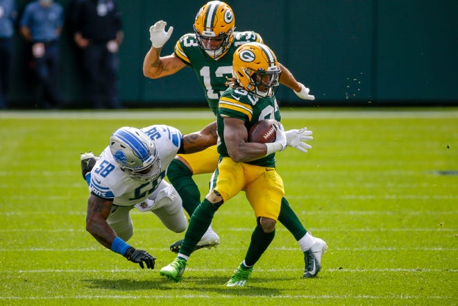 Green Bay Packers' Aaron Jones runs past Detroit Lions' Jamie Collins during the first half of an NFL football game Sunday, Sept. 20, 2020, in Green Bay, Wis.
