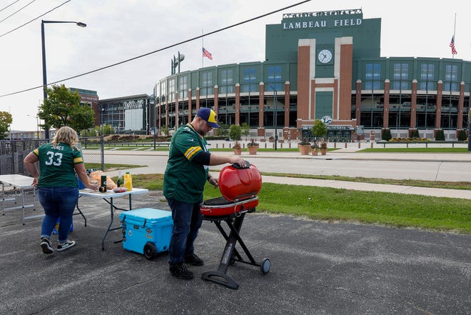 Fans tailgate in a lot across from Lambeau Field before the game.